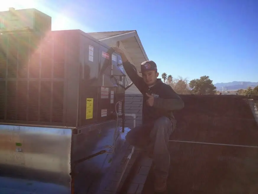 HVAC technician performing AC Tune-Up on a rooftop unit in Plattsmouth